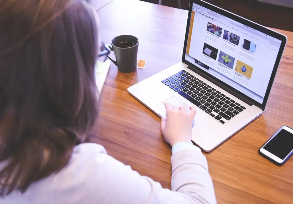 A person working on a laptop at a desk