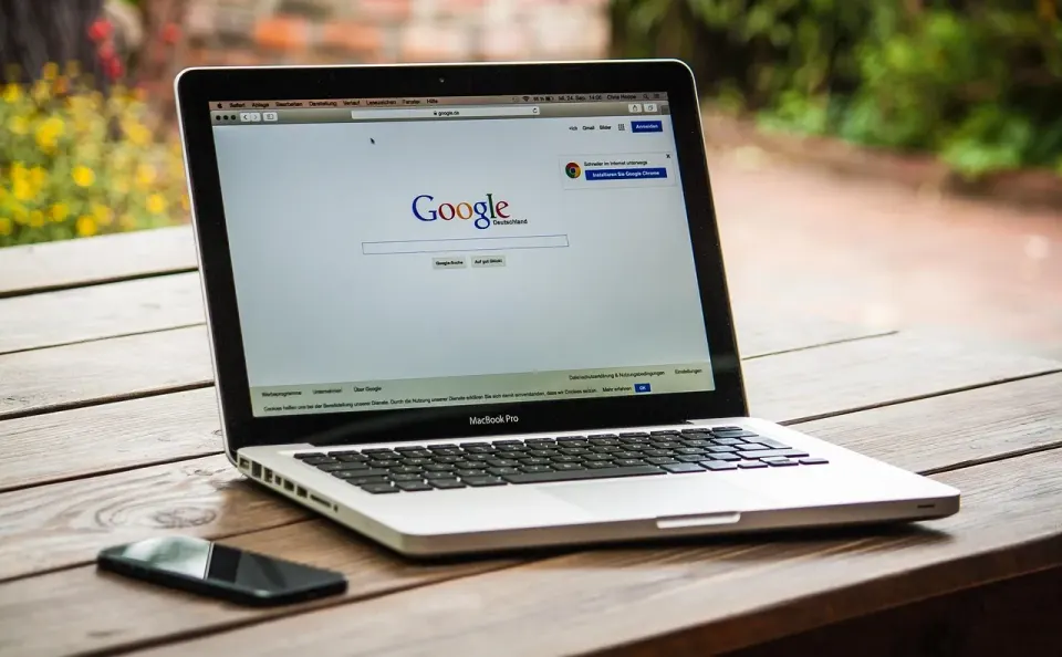 Laptop on a desk with the Google search page open on screen