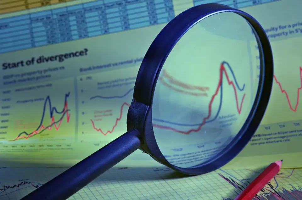 A magnifying glass over data and documents, a picture of checking analytics records closely