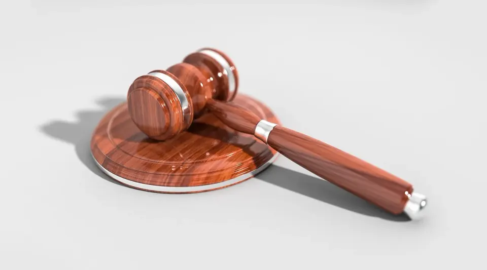 A wooden judge gavel resting on a desk