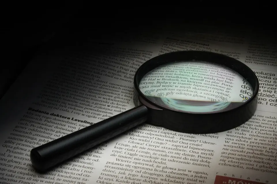 A magnifying glass resting on an old newspaper